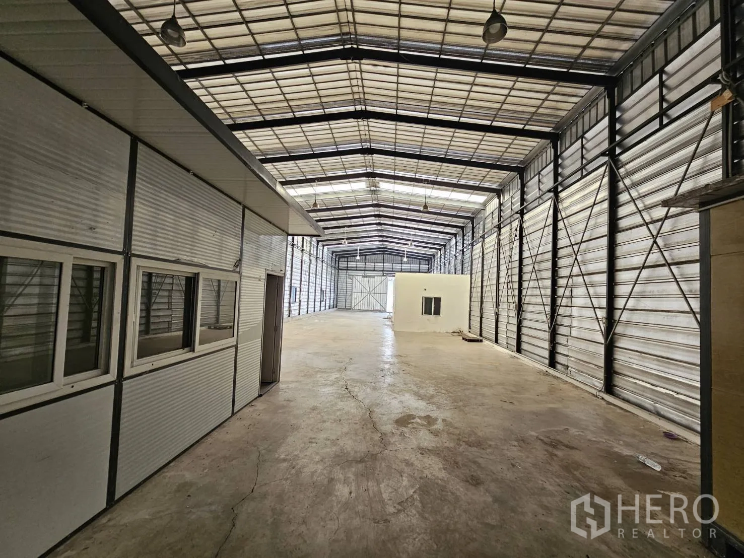 仓库 for rent in Bang Phli, Samut Prakan - 沿模块化办公室的通道视角，高屋顶下设吊灯与钢制墙体。