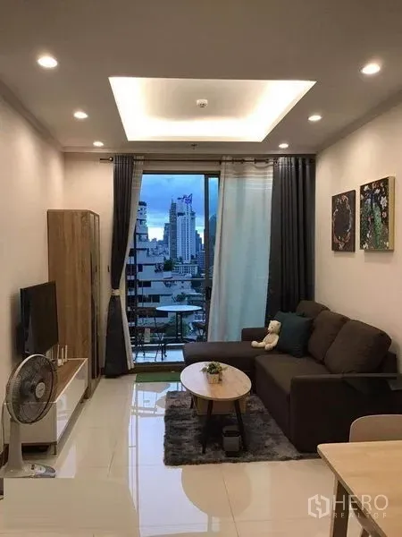 คอนโด ให้เช่าในWatthana, Bangkok - ห้องนั่งเล่นอบอุ่น โซฟา ทีวี และระเบียงเปิดรับวิวเมือง