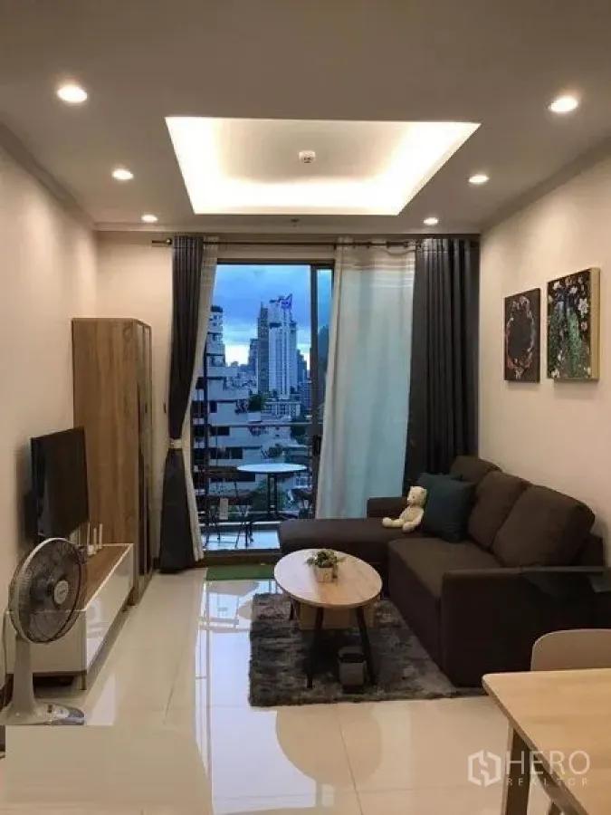 คอนโด ให้เช่าในWatthana, Bangkok - ห้องนั่งเล่นอบอุ่น โซฟา ทีวี และระเบียงเปิดรับวิวเมือง