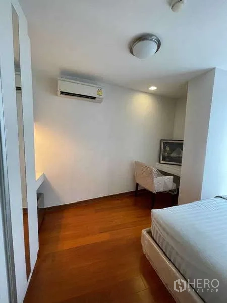 Condominium for sale in Watthana, Bangkok - Second bedroom with desk, air-conditioning and wood floors.