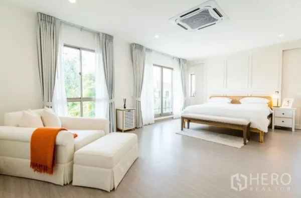 独立式住宅 出租 - 明亮的主卧，配大床与沙发，落地窗与阳台门，天花板嵌入式空调。
