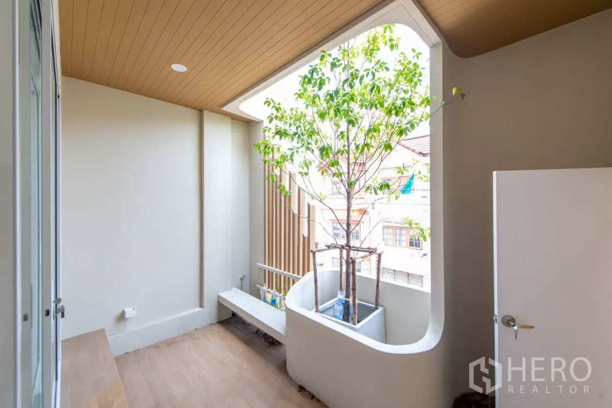 Townhouse for sale in Lat Phrao, Bangkok - Private balcony with built-in bench and planter tree creating a pocket garden.
