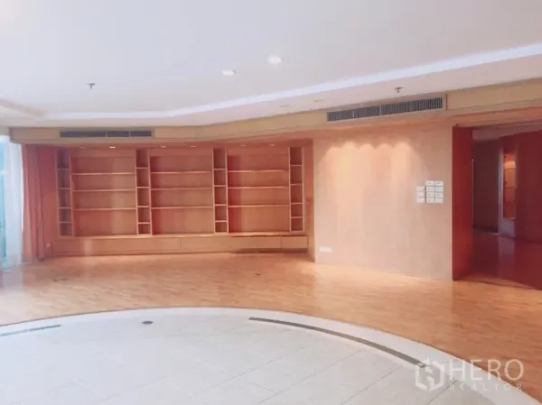 คอนโด ให้เช่าในWatthana, Bangkok - โถงรับแขกกว้าง มีพื้นกระเบื้องวงกลมยกสเต็ปและชั้นหนังสือไม้เต็มผนัง