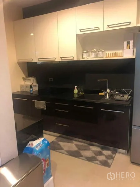 Detached House for rent or sale in Bang Kapi, Bangkok - Sleek kitchen with glossy cabinets, black countertop and sink.