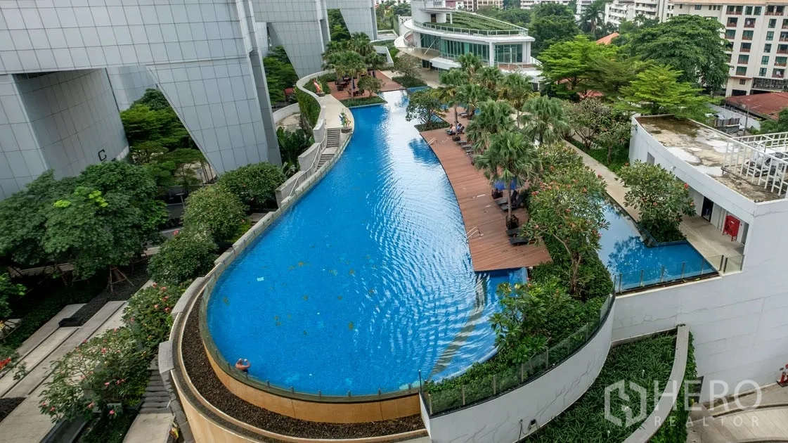 公寓 出租在Khlong Toei, Bangkok - 公寓度假风弧形泳池，木栈道、日光躺椅与热带花园。