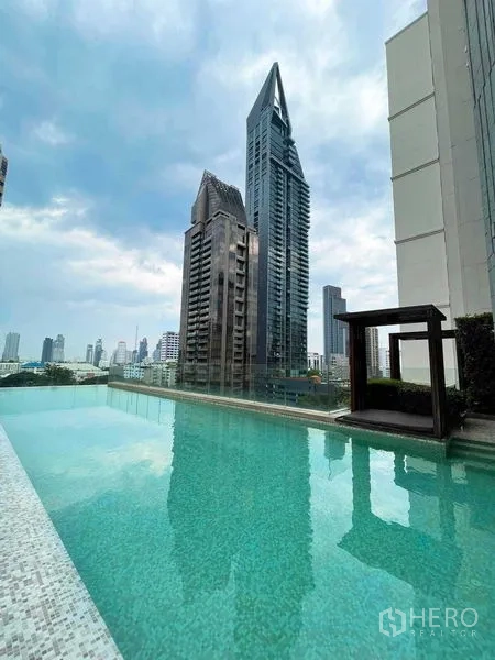 Condominium for rent in Khlong Toei, Bangkok - Rooftop swimming pool with panoramic city skyline backdrop.