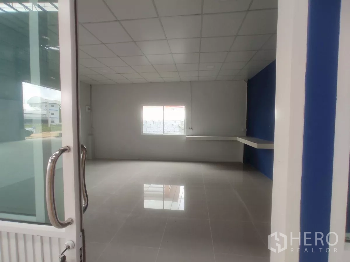 Factory for sale in Khlong Toei, Bangkok - Office room with window and built-in counter viewed through sliding glass door.