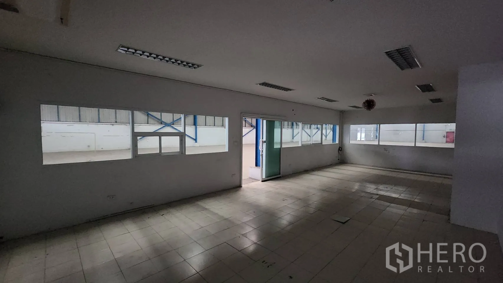Warehouse for rent in Mueang Samut Prakan, Samut Prakan - Open-plan office with glass entry door, multiple windows and ceramic tile flooring.