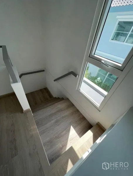 独立式住宅 出租在Min Buri, Bangkok - 楼梯采用木质踏步，竖窗引入自然光。
