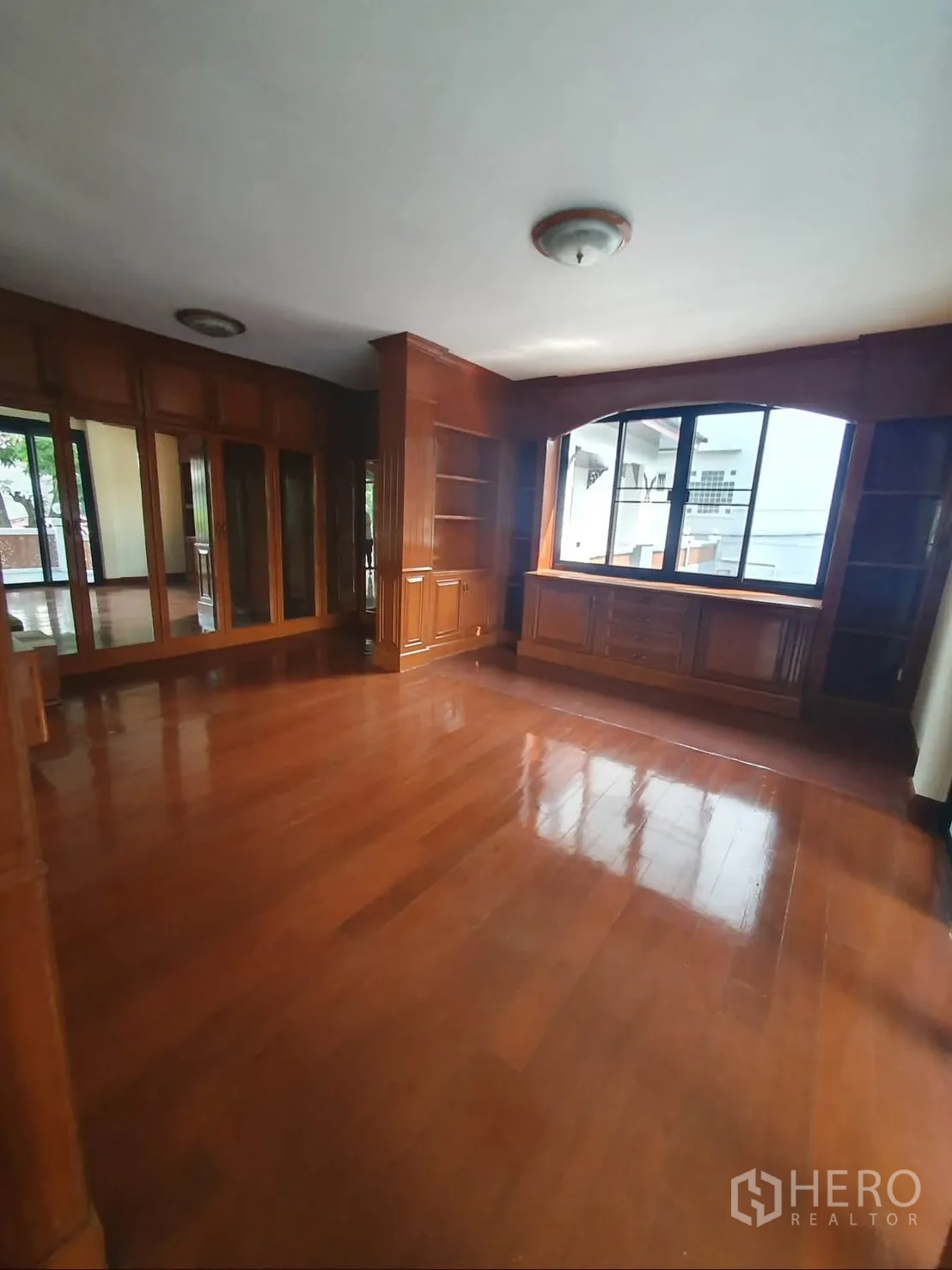 独栋房屋 for rent in Sathon, Bangkok - 房间配抛光木地板、大窗与内置书架柜。