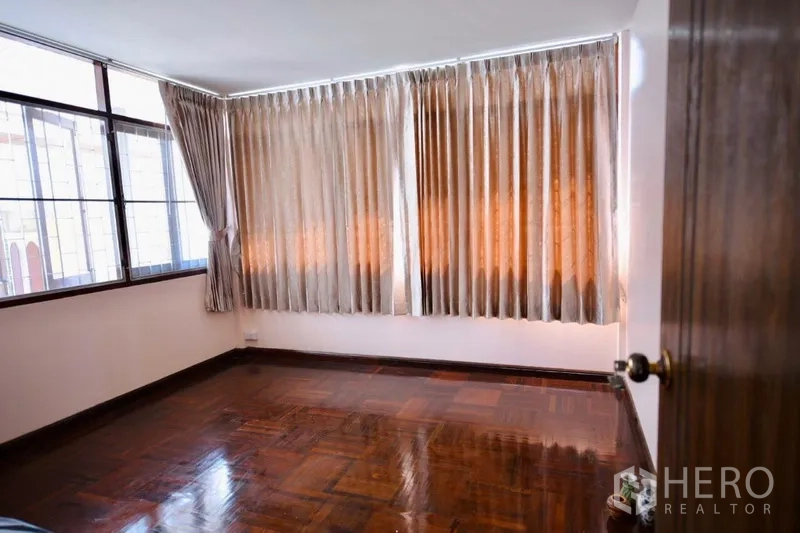 บ้าน ให้เช่าในBang Na, Bangkok - ห้องนอนสว่าง มีผ้าม่านเต็มผนังและพื้นปาร์เกต์เงา