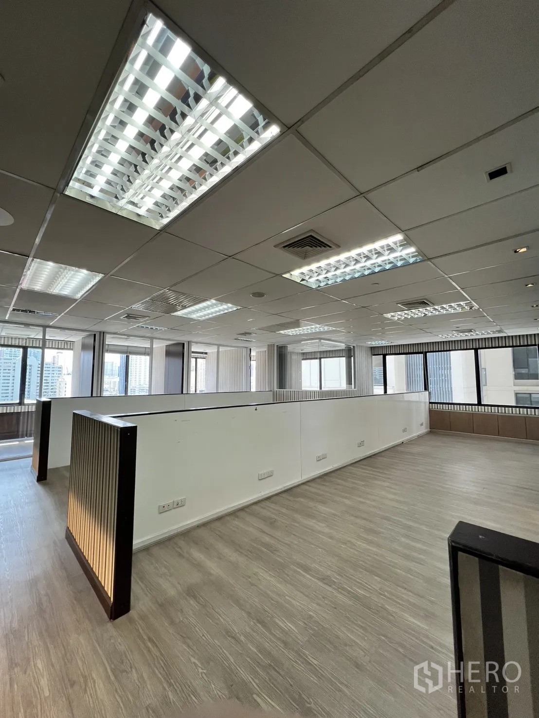 Office Space for rent in Watthana, Bangkok - Open-plan office with ceiling grid lights and city-view windows.