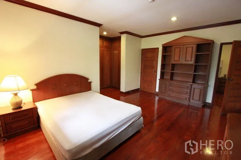 独立式住宅 出租在Prawet, Bangkok - 温馨卧室，内置置物架和衣柜，转角窗与木地板。