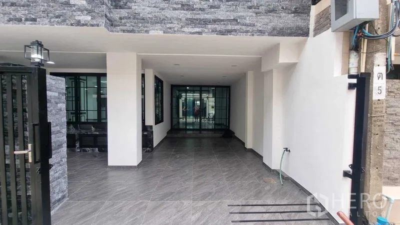 联排别墅 出租在Khlong Toei, Bangkok - 带顶前庭和入口，灰色地砖与立柱，可用于停车。