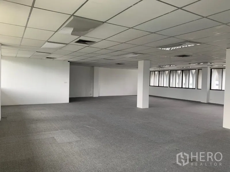 Office Space for rent in Ratchathewi, Bangkok - Unfurnished office floor plate with columns, carpet tiles, and ceiling panels ready for tenant fit-out.