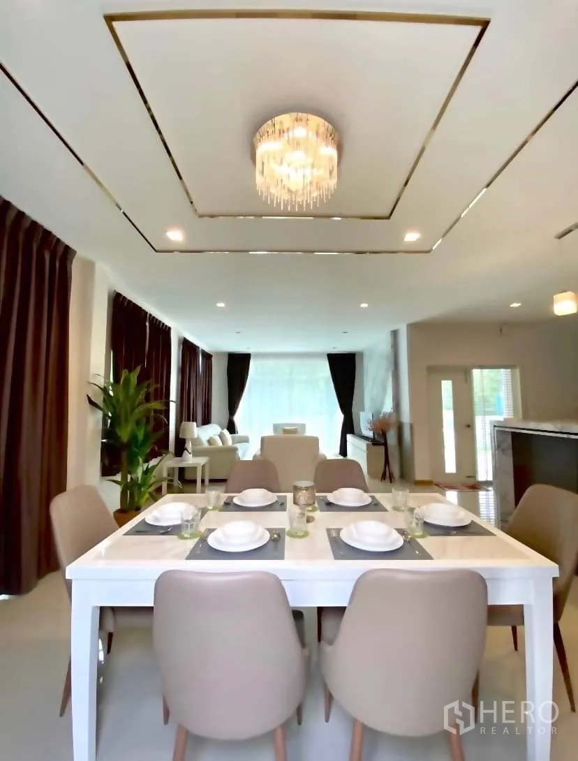 Detached House for rent or sale in Prawet, Bangkok - Bright dining area with a six-seat table beneath a crystal chandelier.