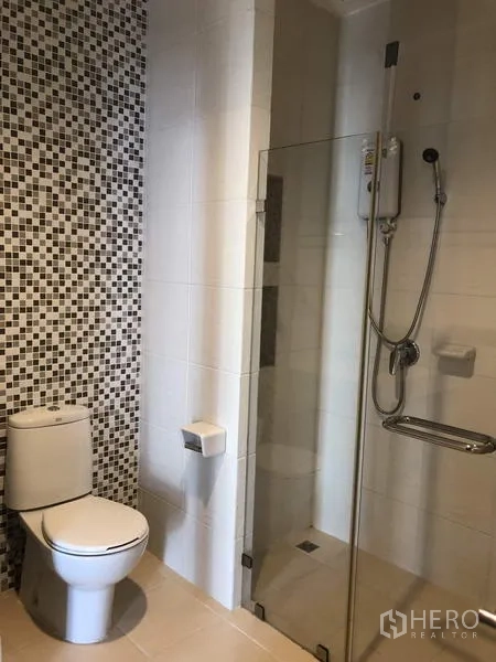Townhouse for rent in Yan Nawa, Bangkok - Bathroom with glass shower enclosure, mosaic feature wall and modern fixtures.