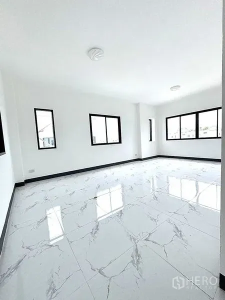 Warehouse for rent in Khlong Luang, Pathum Thani - Spacious open-plan room with multiple black-frame windows and glossy white tiles.