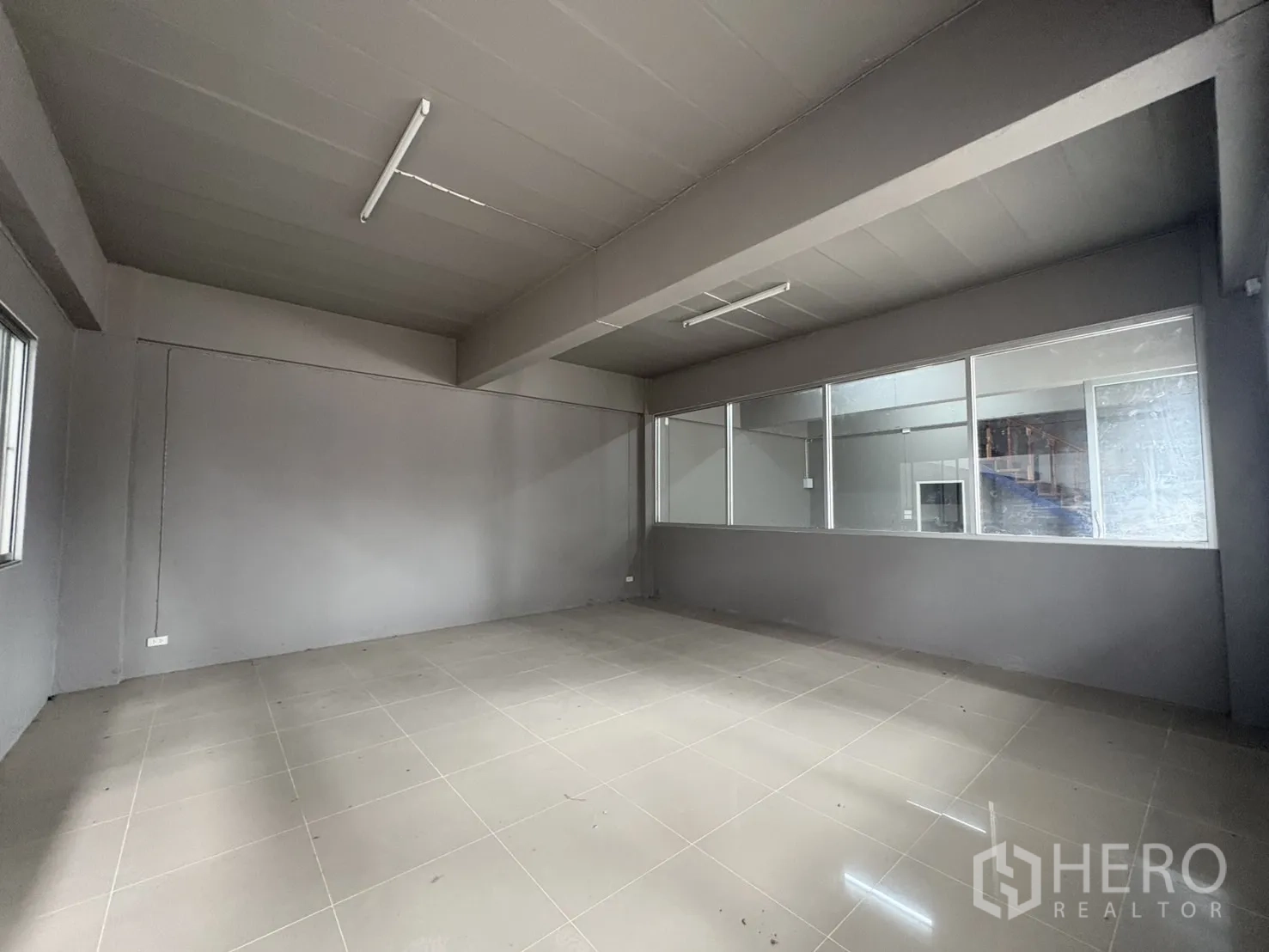 Warehouse for rent in Mueang Samut Prakan, Samut Prakan - Ground-floor office room with glass partition overlooking the warehouse.