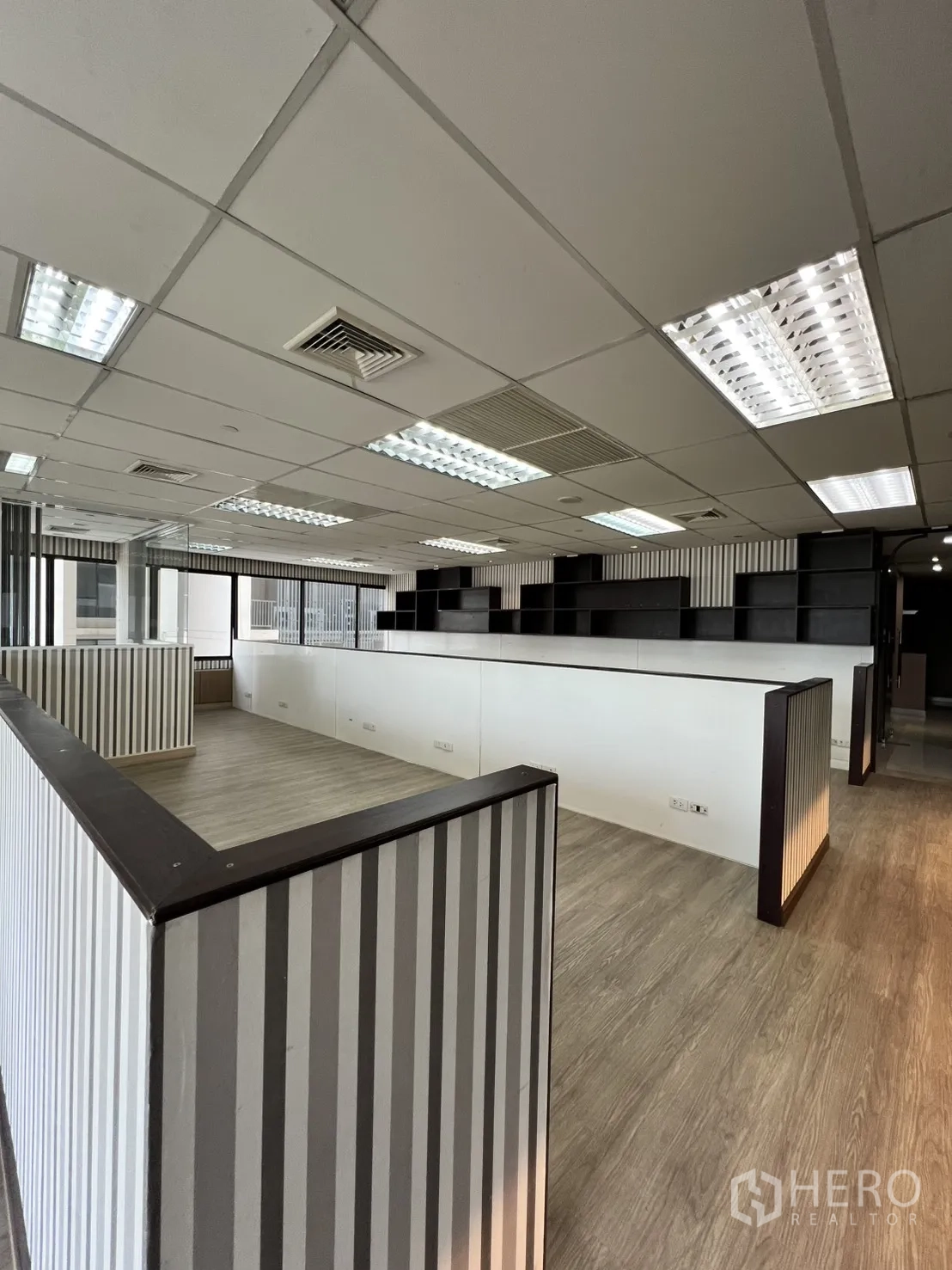 Office Space for rent in Watthana, Bangkok - Work area with striped half-height partitions and wood-style flooring.