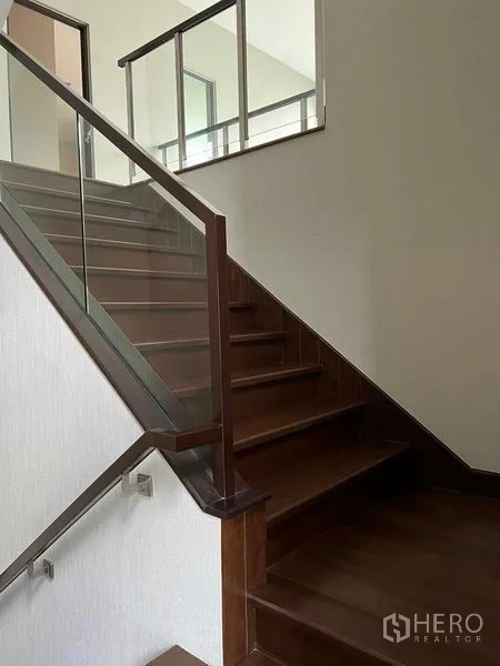 Detached House for sale in Bang Kruai, Nonthaburi - Close-up of wooden stairs with sleek glass balustrade.