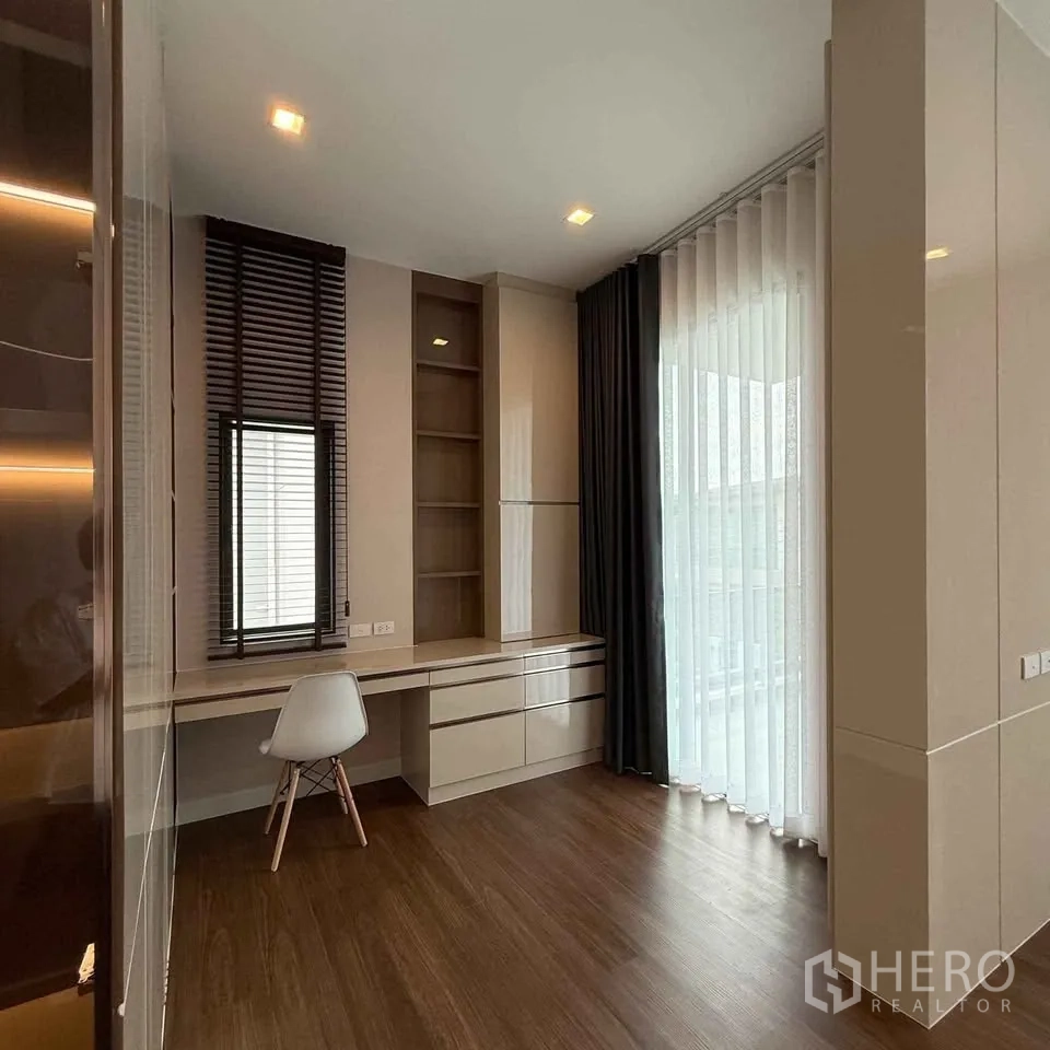 Detached House for rent in Bang Phli, Samut Prakan - Corner room with long desk, window blinds and sheer sliding door curtains.