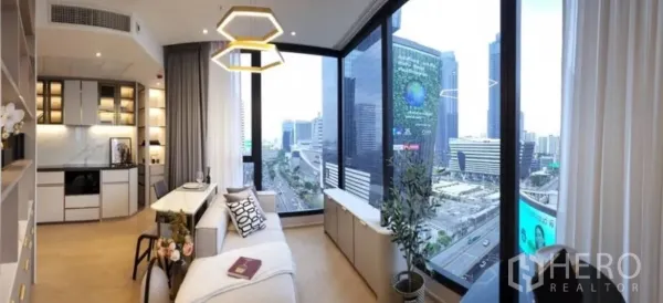 Condominium for rent in Din Daeng, Bangkok - Corner living area with floor-to-ceiling windows offering panoramic city skyline views near Phra Ram 9.