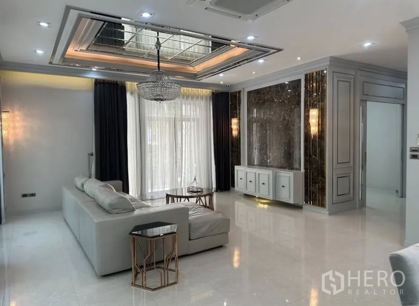 Detached House for rent or sale in Prawet, Bangkok - Open-plan living and dining zone with glossy floors, marble feature wall, and sliding glass doors.