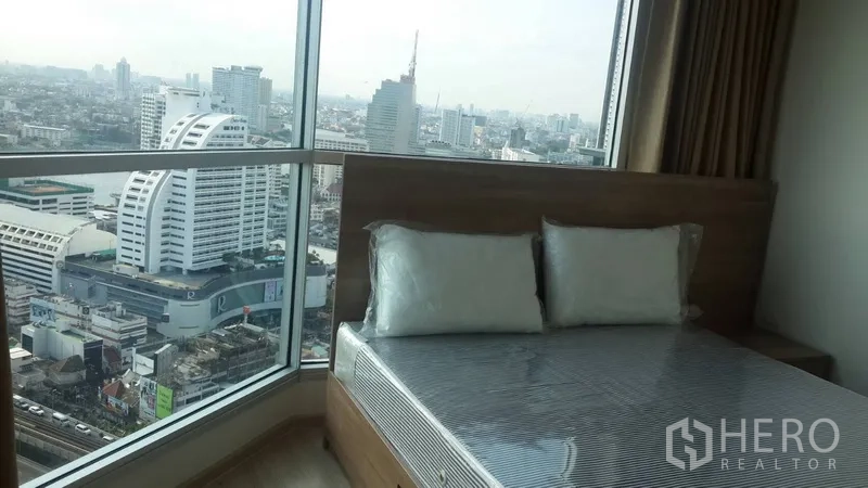 公寓 出租或出售在Sathon, Bangkok - 温馨卧室，床位紧邻全景窗，城市景致尽收眼底。