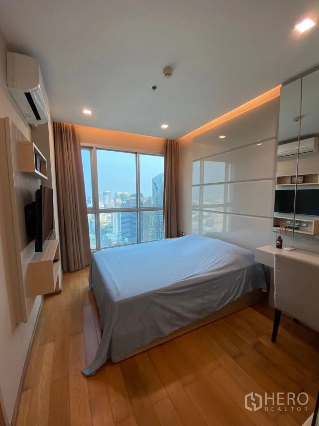 公寓 出租在Ratchathewi, Bangkok - 卧室采光充足，大窗与柔和灯带，内置收纳，享宽阔城市景观。