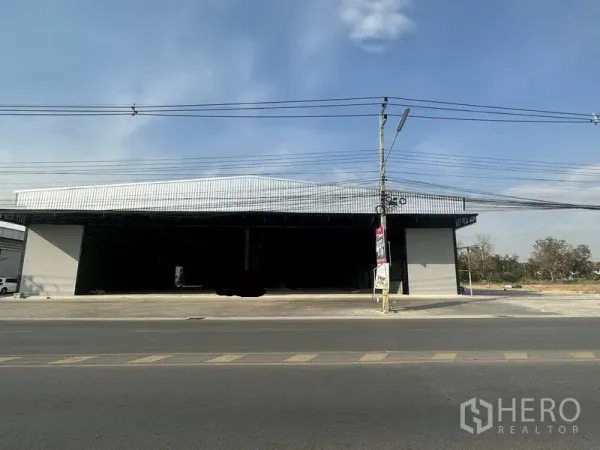 Warehouse for rent in Lam Luk Ka, Pathum Thani - Front elevation showing twin wide entry bays of the warehouse and a spacious apron facing the main road.