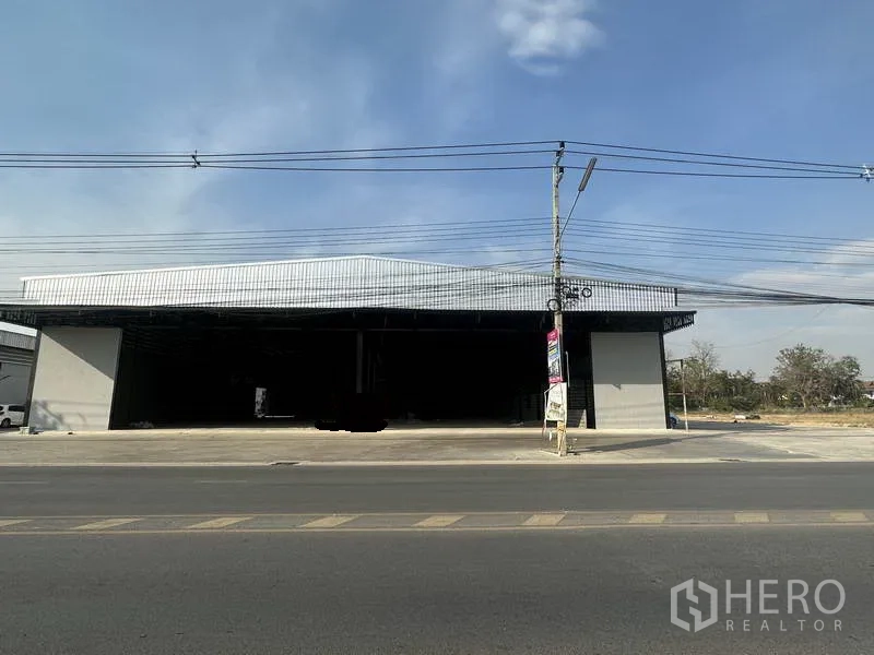 Warehouse for rent in Lam Luk Ka, Pathum Thani - Front elevation showing twin wide entry bays of the warehouse and a spacious apron facing the main road.
