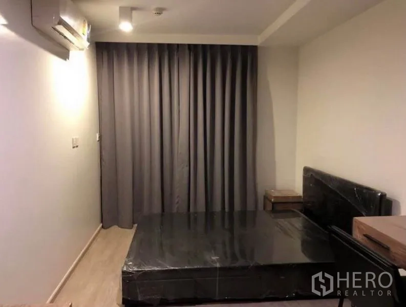 Condominium for rent or sale in Pathum Wan, Bangkok - Bedroom with bed frame, bedside tables, grey blackout curtains and air conditioning.