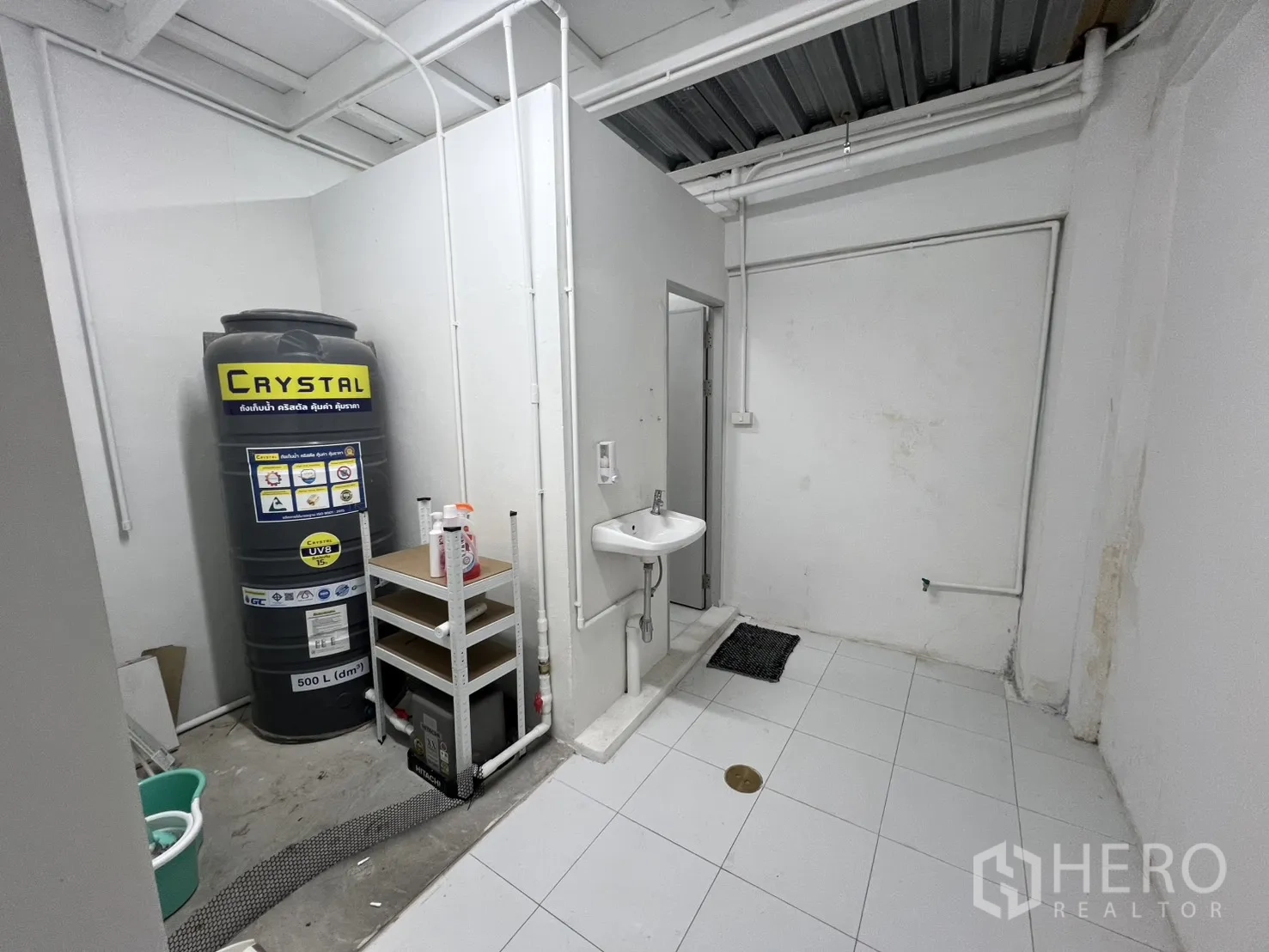 Shophouse for rent or sale in Khlong Toei, Bangkok - Service area with sink, water tank and utility shelving.