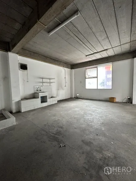 Retail Space for rent in Khlong Toei, Bangkok - Raw concrete retail area featuring a sink, wall shelving, exposed ceiling and a window.