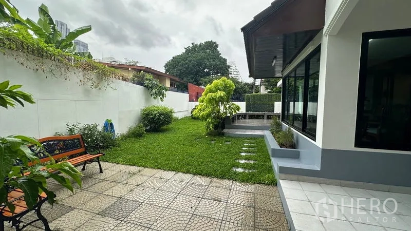 独立式住宅 出租在Watthana, Bangkok - 私家庭院草坪，铺装露台与长椅。