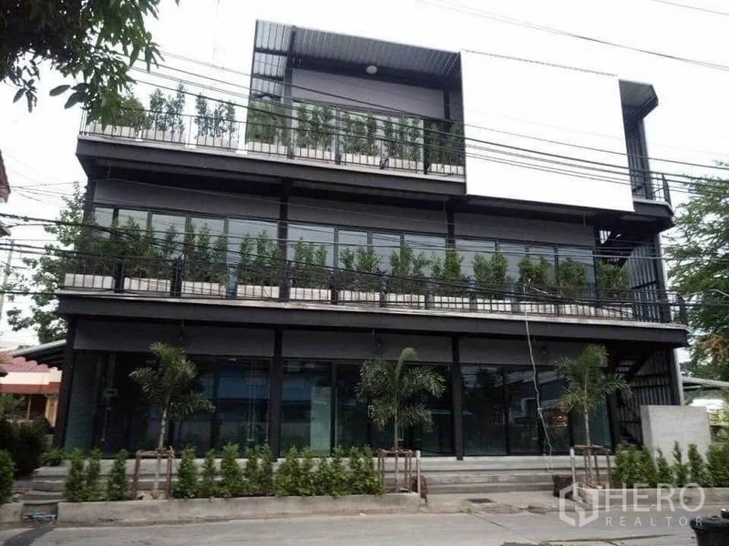 Home Office for rent in Din Daeng, Bangkok - Modern three-storey home office building with full-height glass and balcony planters.