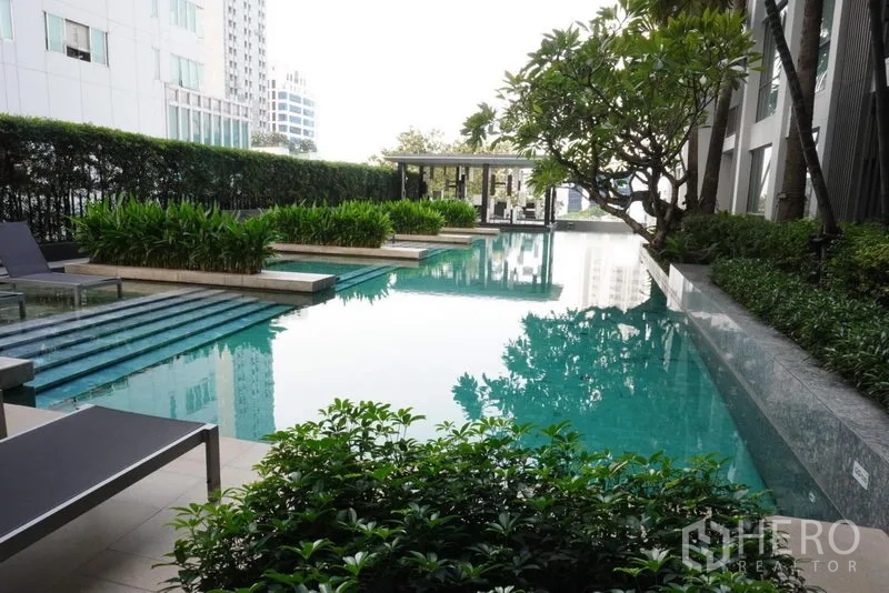 Condominium for rent in Watthana, Bangkok - Resort-style swimming pool with lush greenery and sun loungers at Quattro by Sansiri.