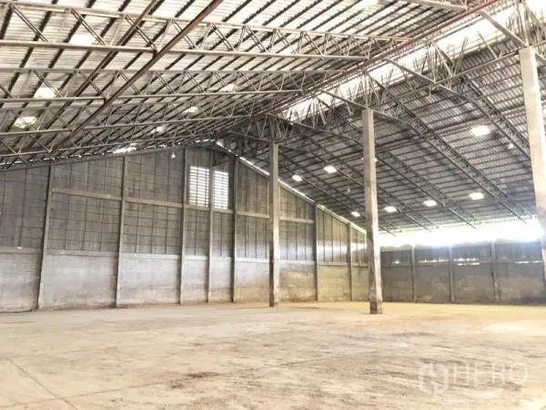 Warehouse for rent in Phra Nakhon Si Ayutthaya - Spacious warehouse interior with high steel truss roof, ventilated walls and concrete floor.