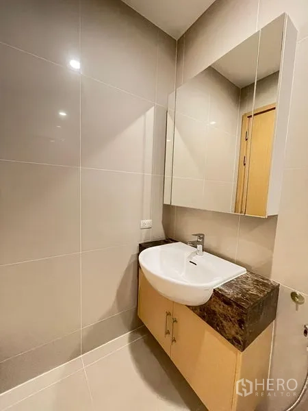 Condominium for rent in Watthana, Bangkok - Compact guest bathroom with wall-mounted basin and marble countertop.