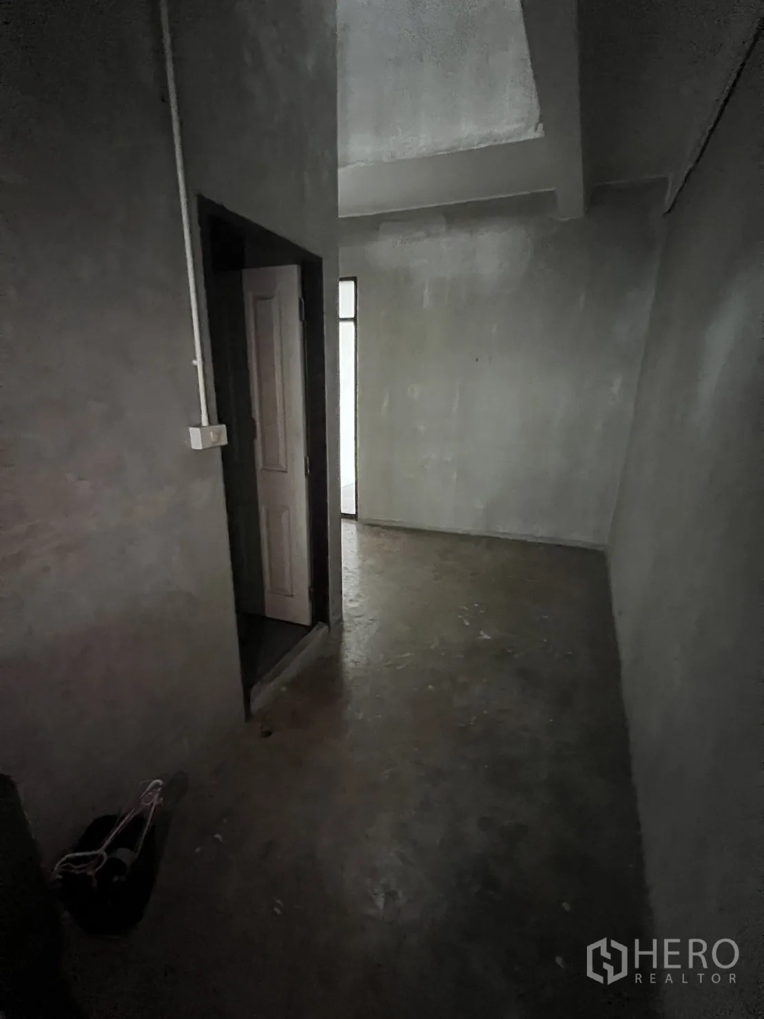 Shophouse for rent in Watthana, Bangkok - Narrow corridor with doorways and bare concrete surfaces.