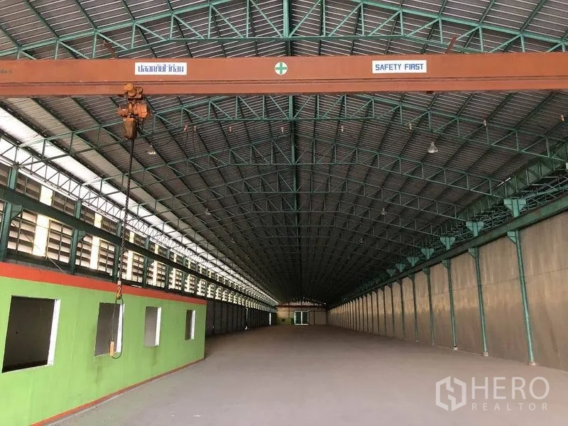 Warehouse for rent in Samut Prakan - Close-up of gantry beam with chain hoist inside the large ventilated warehouse.