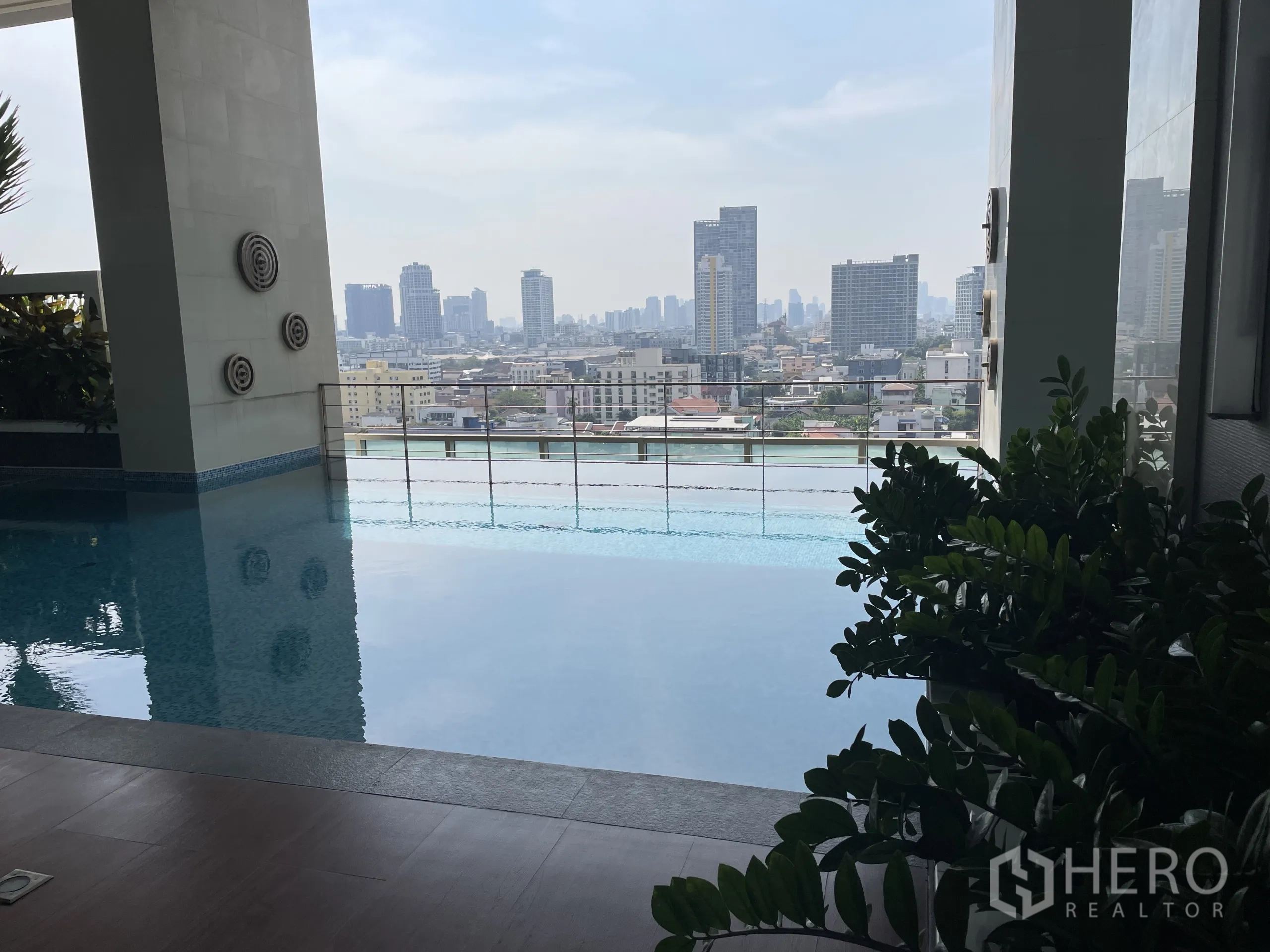 คอนโด ขายในChatuchak, Bangkok - สระว่ายน้ำกึ่งในร่มมองเห็นเมืองกรุงเทพฯ ผ่านช่องเปิดระเบียง
