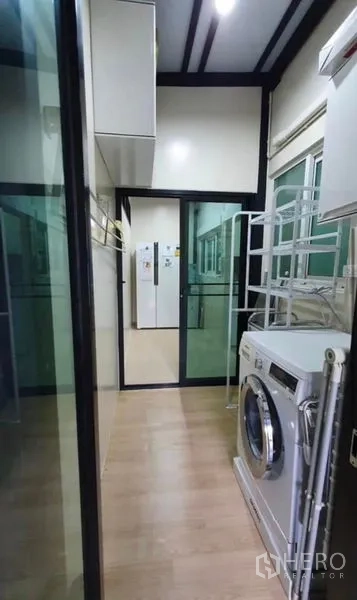 Detached House for rent or sale in Lat Krabang, Bangkok - Laundry area with washing machine, storage shelves and sliding glass doors.
