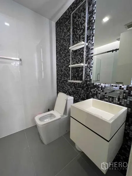公寓 出租在Watthana, Bangkok - 现代卫浴，方形台盆、马赛克特色墙与坐便器。