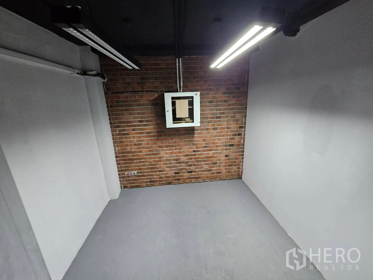 办公空间 出租在Watthana, Bangkok - 小型私密房，砖纹特色墙、黑色天花与明亮灯带。