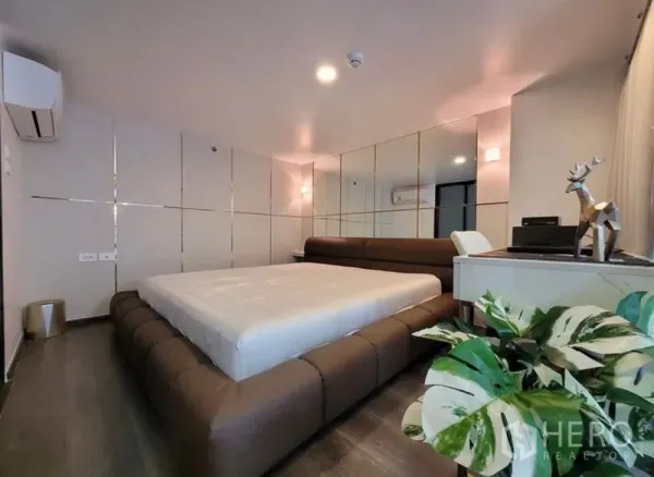 公寓 出租在Chatuchak, Bangkok - 现代卧室，低矮平台床，镜面墙板、书桌与空调。