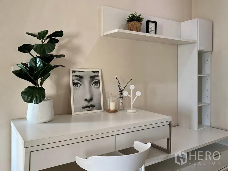 Condominium for rent in Khlong Toei, Bangkok - Minimalist study area with desk, floating shelf and decor pieces.