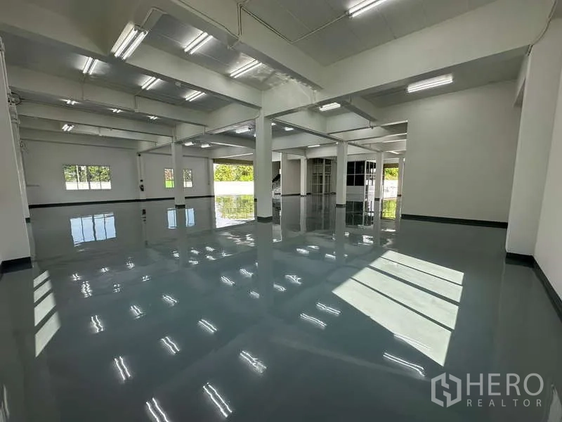 货栈 出租在Mueang Samut Prakan, Samut Prakan - 开放式仓库内部，地面反光，采光窗临近装卸区。