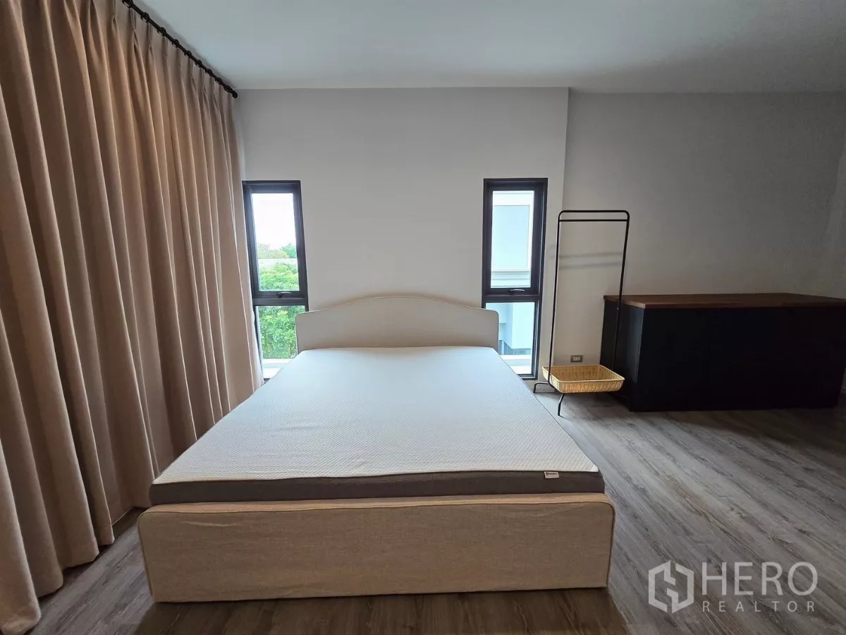 独立式住宅 出租在Prawet, Bangkok - 卧室内双人床、长窗帘与窄条窗。